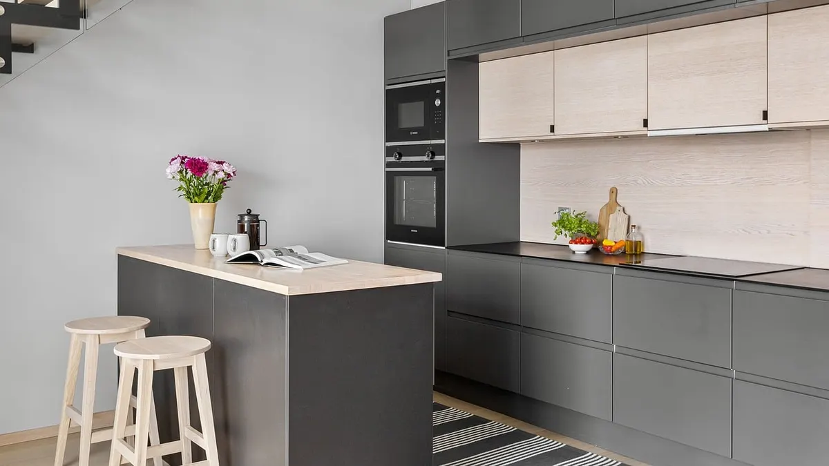 Cozinha moderna com armários cinza, bancada e banquetas