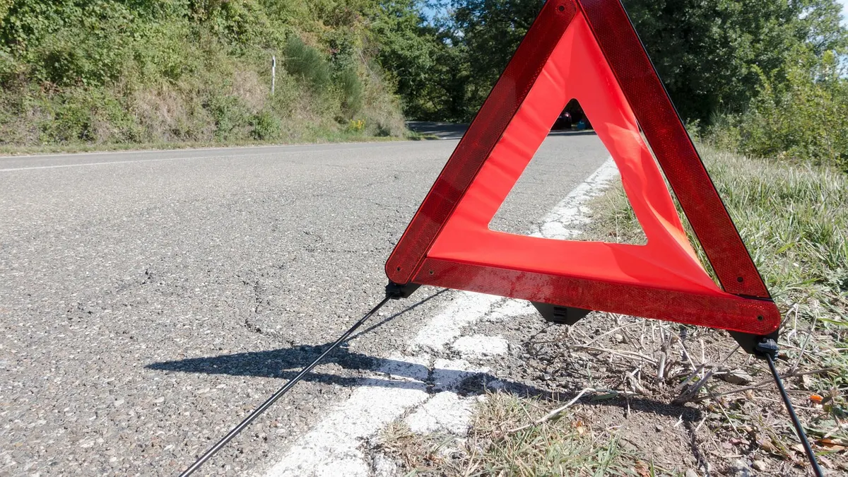 Triângulo de sinalização vermelho na pista de uma estrada